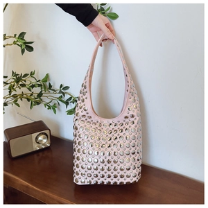 Détail du sac hobo rose clair avec rivets métalliques argentés et large bandoulière