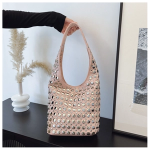 Détail du sac hobo en cuir rose avec clous en métal argenté et bandoulière intégrée