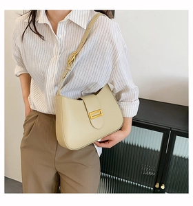 Chic beige leather baguette bag for women shown as a stylish shoulder bag on a model