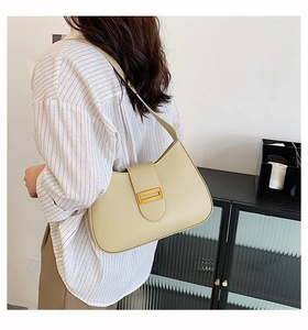 Detail view of beige PU leather baguette bag featuring a sleek gold metallic buckle
