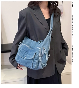 Detail of light blue denim crossbody bag with metal snap button and zipper pockets
