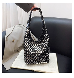 Détail du sac hobo en cuir noir souple orné de rivets métalliques argentés