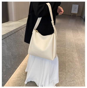 Detail of adjustable wide shoulder strap on cream large tote bag with metallic buckle