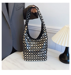 Gros plan d'un sac punk noir avec des clous métalliques argentés sur marbre chic