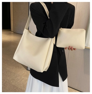 Detail view of cream white minimalist tote bag and zipper pouch set worn by model