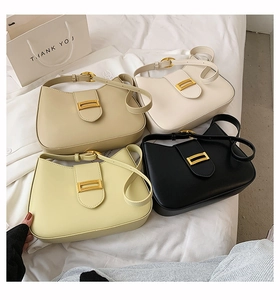 Multiple colors of matte baguette underarm bags with gold metal buckles on a soft background