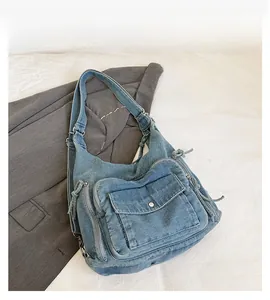 Detail of vintage washed denim blue shoulder bag with multi-pocket and zipper design