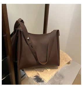 Detailed mirror view of dark brown leather tote bag with wide adjustable shoulder strap