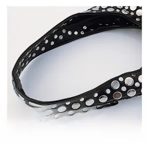Détail macro de la bandoulière en cuir noir avec des rivets métalliques argentés stylés