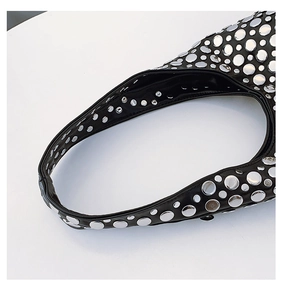 Détail des rivets métalliques argentés sur la bandoulière en cuir noir au style punk