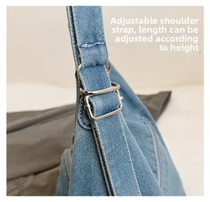 Detail of adjustable denim strap with silver metal buckle on large tote bag