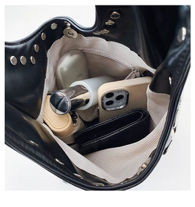 Détail du sac noir à rivets avec doublure à chevrons gris et poche zippée intérieure