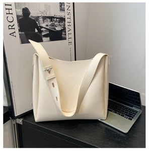 Detail of adjustable silver buckle on cream white tote bag in professional setting