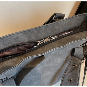 Détail de la fermeture éclair en métal et texture suédine mate sur le grand sac cabas