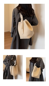 Detail of creamy white leather bucket bag with pebble texture and adjustable wide strap