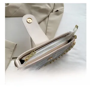 Detail view of the smooth zipper closure and premium tweed texture on the beige crossbody bag