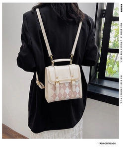 Detail of pink argyle pattern on cream leather backpack with gold metal hardware