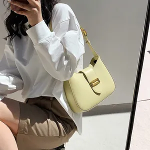 Chic lime yellow baguette underarm bag with gold metal buckle shown on a female model