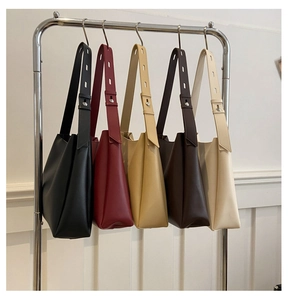 Row of minimalist tote bags in five different colors hanging on a metal clothing rack