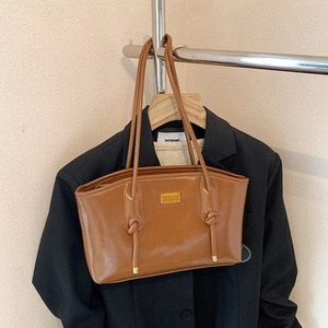 Brown faux leather underarm tote bag with gold logo and stylish knotted shoulder strap