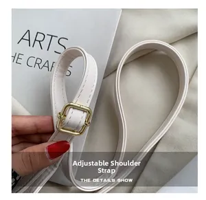 Detail of adjustable PU leather shoulder strap with gold metal buckle and fine stitching