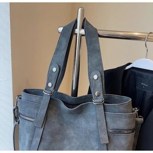 Détail du sac cabas en daim gris avec clous argentés et fermeture éclair latérale