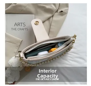 Detail view of spacious inner compartment of beige shoulder bag with phone and lipstick