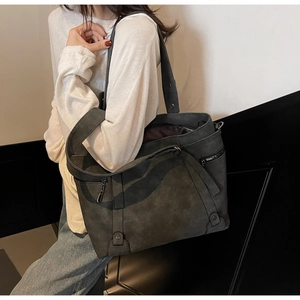 Détail du grand sac cabas gris foncé en cuir synthétique mat porté par un mannequin
