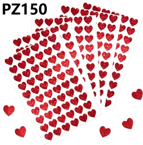 Gros plan d'autocollants cœurs rouges pailletés avec quatre feuilles et pièces éparses
