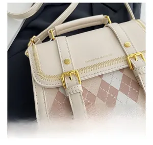 Close-up of beige quilted backpack with pink accents and gold metal hardware