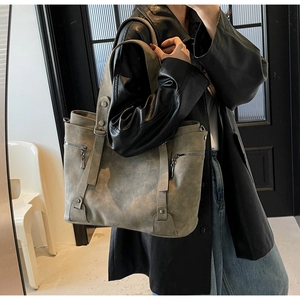 Détail du grand sac cabas gris vintage avec sangles verticales, rivets et fermetures éclair
