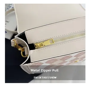 Detailed close-up of a white and pink checkered bag with a premium golden hardware zipper