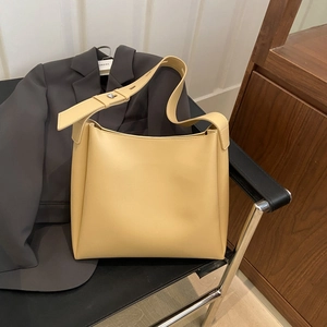 Minimalist cream yellow leather hobo shoulder bag with silver metallic stud detail