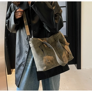 Détails d'un grand sac cabas en daim vert olive avec sangles décoratives et rivets en métal