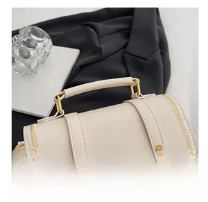Close-up of the comfortable cream leather handle and golden buckle on a quilted bag