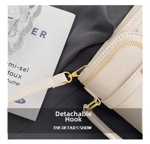 Detail of detachable gold hook and wavy embroidery on cream quilted faux leather backpack