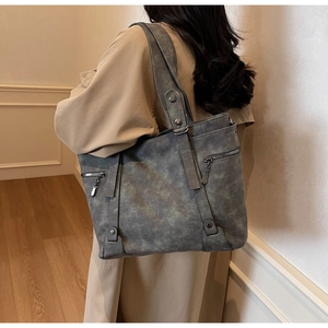 Vue détaillée du grand sac cabas vintage gris montrant les rivets et la texture