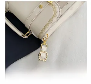Detail showing adjustable leather strap with gold buckle and woven embossed stitching