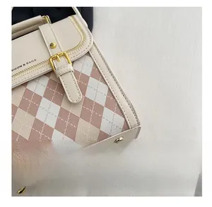 Detailed macro view of pink diamond pattern stitching and gold hardware on cream bag