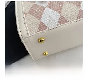 Close-up of durable golden metal studs and argyle fabric stitching on the bag base
