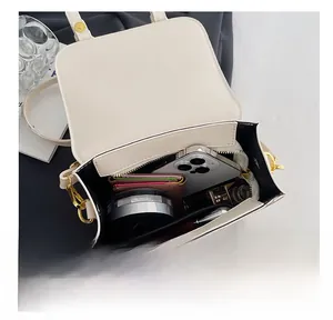 Interior view showing capacity of the white PU leather bag with phone and wallet