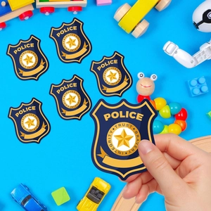Gros plan d'une main tenant un autocollant de badge de police pour fête d'enfants