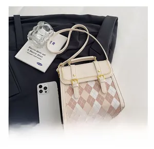 Mini crossbody bag size comparison with smartphone showing quilted texture and top handle