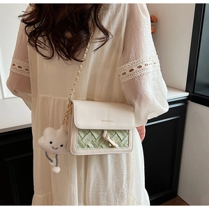 Detail of woven sage green and cream small square bag with cute cloud charm and chain strap