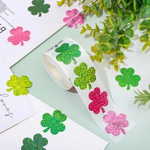 Roll of glittery shamrock stickers in assorted colors for envelope sealing and decor