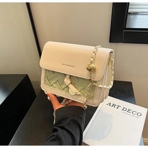Detail of light green woven leather texture and fashion print on chic crossbody bag