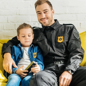 Détails des badges de police sur uniforme noir et veste bleue sur un canapé jaune