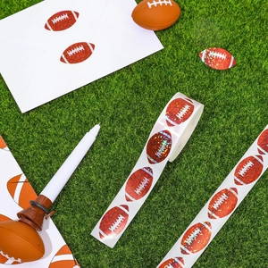 Laser holographic football stickers roll with sports whistle pen on green turf background