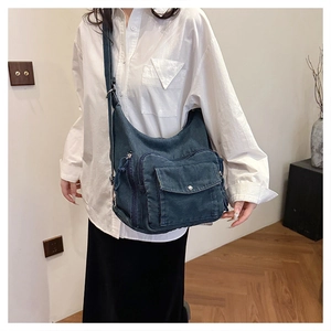 Lifestyle view of a vintage dark blue denim crossbody bag worn over a white shirt