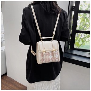 Detail of pink and beige quilted faux leather backpack worn by model in soft lighting